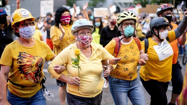 In Portland stellte sich am Montag auch eine Mauer aus Müttern (Wall of Moms) schützend vor die Demonstrierenden. Sie wollen verhindern, dass ihre Söhne von den mit massiver Gewalt operierenden Spezialeinheiten des Bundes verletzt werden. In Portland stellte sich am Montag auch eine Mauer aus Müttern (Wall of Moms) schützend vor die Demonstrierenden. Sie wollen verhindern, dass ihre Söhne von den mit massiver Gewalt operierenden Spezialeinheiten des Bundes verletzt werden.