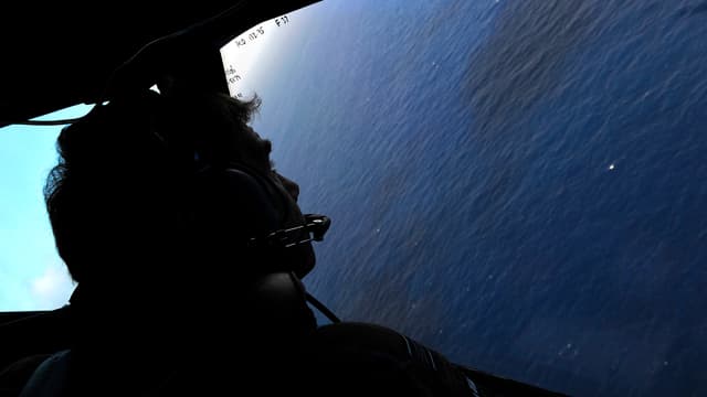 Mann aus Flugzeugfenster auf das Meer blickend Mann aus Flugzeugfenster auf das Meer blickend