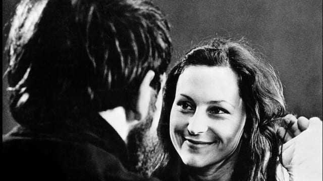 Eine junge Frau blickt ins Gesicht eines Mannes, der nur von hinten sichtbar ist. Eine junge Frau blickt ins Gesicht eines Mannes, der nur von hinten sichtbar ist.