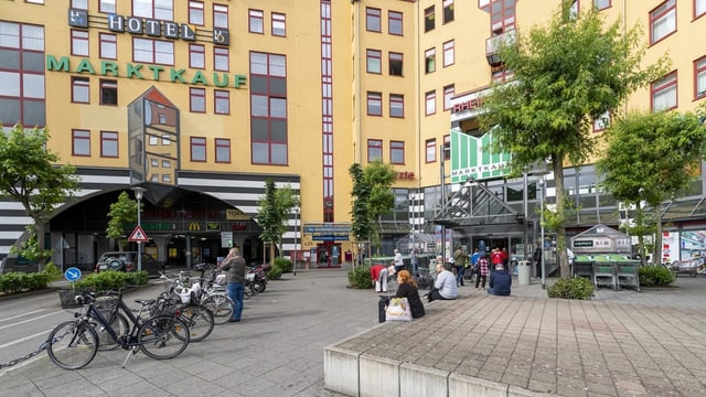 Wenige Leute sitzen auf Vorplatz Wenige Leute sitzen auf Vorplatz