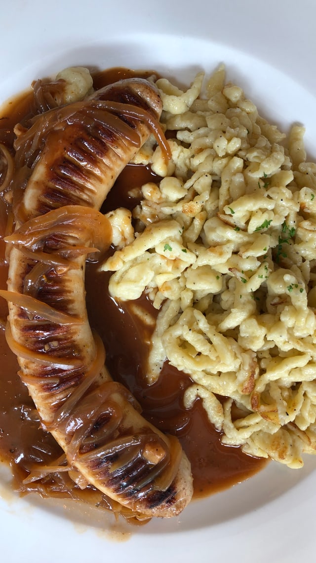 Teller mit Spätzle und Bratwurst. Teller mit Spätzle und Bratwurst.