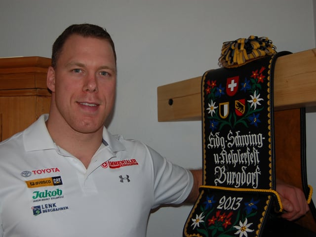 Ein grossgewachsener Mann neben einer Siegertrophäe. Ein grossgewachsener Mann neben einer Siegertrophäe.