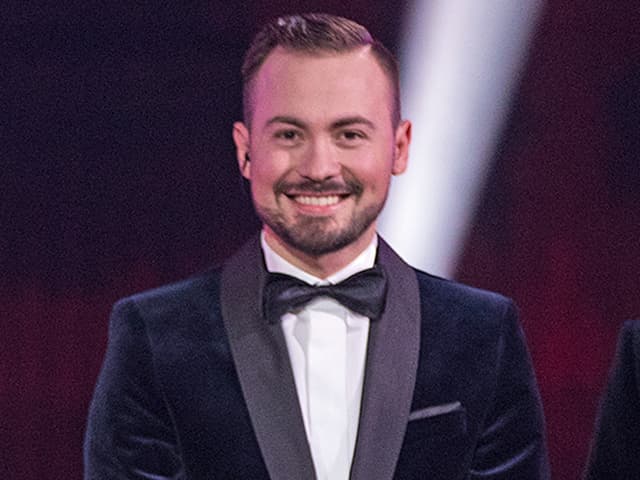 Emanuel steht auf der ESC-Bühne und lächelt Emanuel steht auf der ESC-Bühne und lächelt