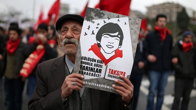Ein älterer Herr hält bei einer Gedenkkundgebung üfr Elvan ein Plakat mit dessen Konterfei hoch Ein älterer Herr hält bei einer Gedenkkundgebung üfr Elvan ein Plakat mit dessen Konterfei hoch