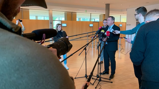Pressekonferenz, ein Mann spricht vor Mikrophonen Pressekonferenz, ein Mann spricht vor Mikrophonen