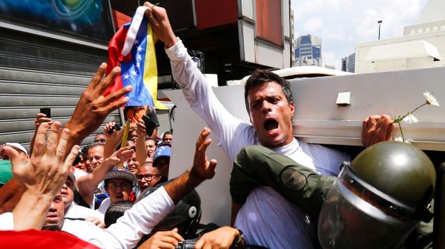 Regierungsgegner Leopoldo López wird in einen Polizeiwagen gedrängt. Regierungsgegner Leopoldo López wird in einen Polizeiwagen gedrängt.