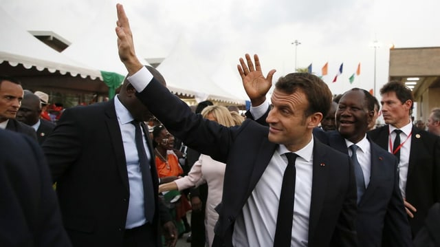 Macron winkt in Elfenbeinküste den Leuten zu. Macron winkt in Elfenbeinküste den Leuten zu.