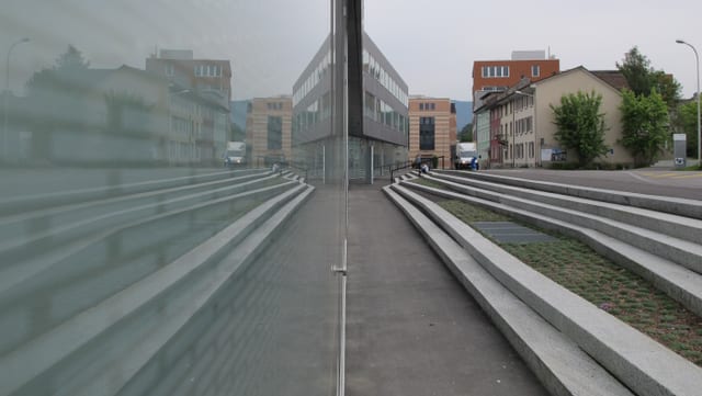 Moderne Glas- und Betongebäude in Olten an einer Strasse, in der Fassade spiegelt sich die Strasse. Moderne Glas- und Betongebäude in Olten an einer Strasse, in der Fassade spiegelt sich die Strasse.