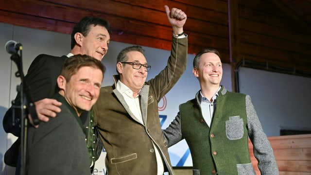 Die vier Gründungsmitglieder der neuen politische Partei stehen auf einer Bühne und feiern. Die vier Gründungsmitglieder der neuen politische Partei stehen auf einer Bühne und feiern.