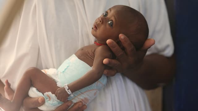 Afrikanisches Baby in den Armen seiner Mutter.