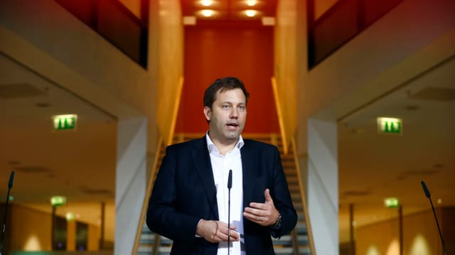 Mann vor Mikrofon. Er redet. Mann vor Mikrofon. Er redet.