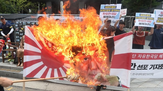 Demonstranten zünden eine Fahne an. Demonstranten zünden eine Fahne an.