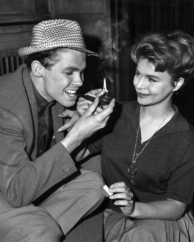 Cornelia zündet die Pfeife ihres Kollegen an. Cornelia zündet die Pfeife ihres Kollegen an.