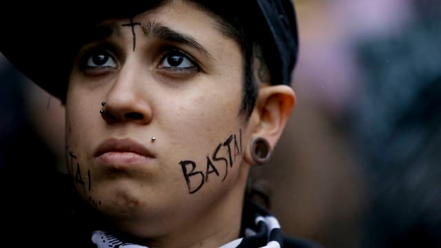 Demonstrationsteilnehmerin mit der Aufschrift «Basta!» an der Wange