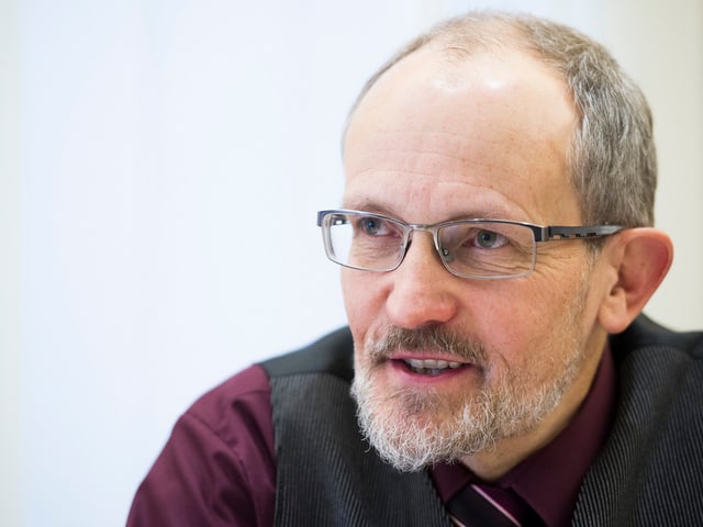 Ein Mann mit grauen Haaren, grauem Bart und schwarzer Brille. Ein Mann mit grauen Haaren, grauem Bart und schwarzer Brille.