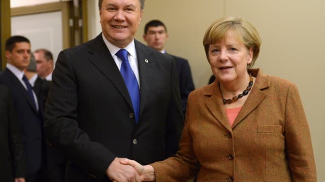Mann und Frau geben sich die Hand und schauen in die Kamera. Mann und Frau geben sich die Hand und schauen in die Kamera.