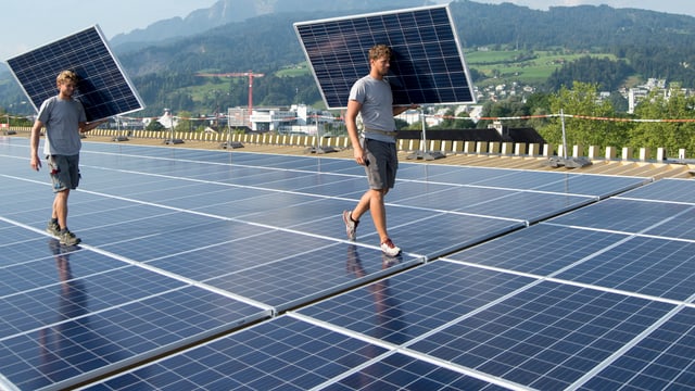 Arbeiter tragen Solarmodule Arbeiter tragen Solarmodule