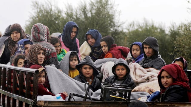 Frauen und Kinder auf einem Wagen zusammengepfercht. Frauen und Kinder auf einem Wagen zusammengepfercht.