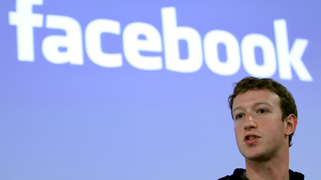 Zuckerberg vor einem Facebook-Logo.