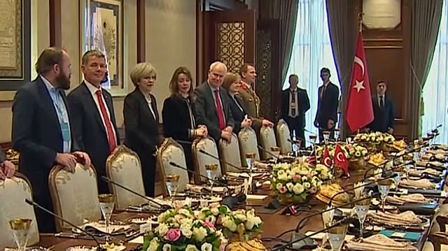 Britische Delegation mit Theresa May stehen am Sitzungtisch. Britische Delegation mit Theresa May stehen am Sitzungtisch.