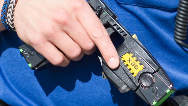 Polizist mit Elektroschockpistole in der Hand Polizist mit Elektroschockpistole in der Hand
