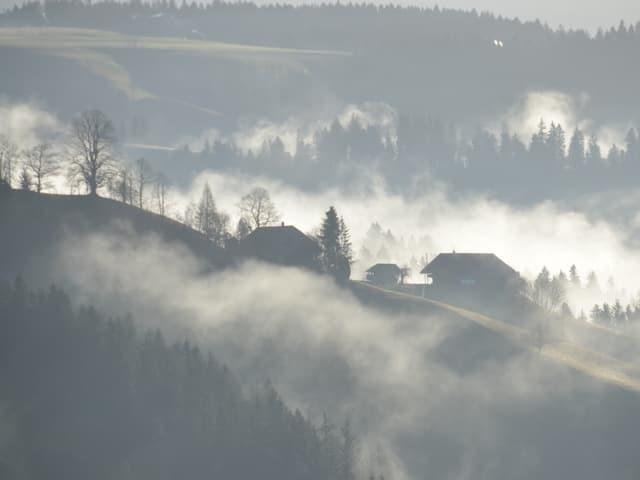 Nebel liegt zwischen den Tälern des Emmentals. Langsam geht die Sonne auf, der Nebel lichtet sich.