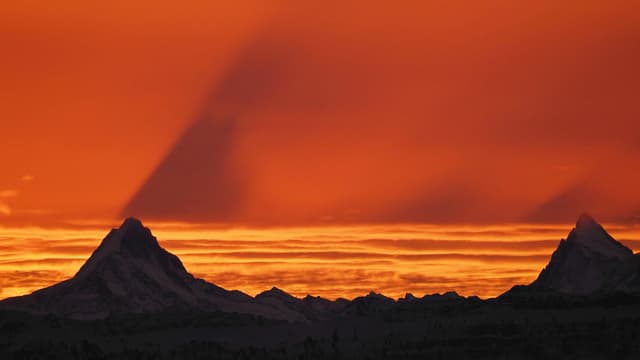 Oranger Himmel, Berge mit Schattenwurf.