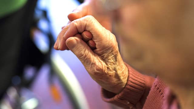 Nahaufnahme der Hand einer Greisin. Die Hand liegt in derjenigen einer Pflegerin. Nahaufnahme der Hand einer Greisin. Die Hand liegt in derjenigen einer Pflegerin.