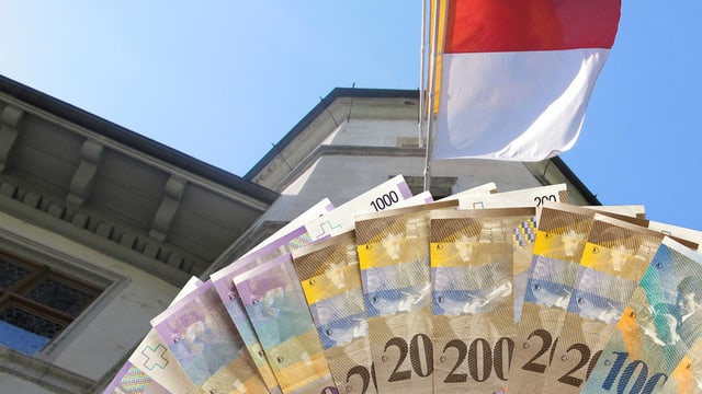 Solothurner Ratshaus mit Kantonsflagge und grossen Geldnoten im Vordergrund. Solothurner Ratshaus mit Kantonsflagge und grossen Geldnoten im Vordergrund.