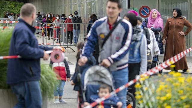 Menschen stehen in einer langen Schlang an. Menschen stehen in einer langen Schlang an.