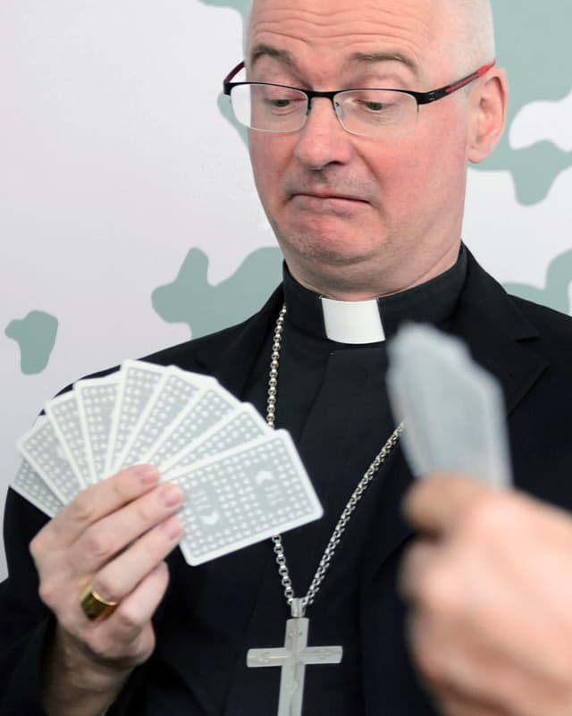 Ein Mann in schwarzem Pfarrersgewand jasst. Ein Mann in schwarzem Pfarrersgewand jasst.