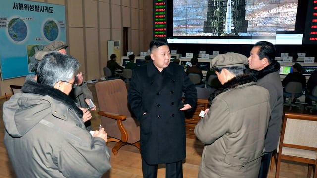 Nordkoreas Führer Kim Jong-Un umringt von Journalisten im Satellitenüberwachungszentrum. Nordkoreas Führer Kim Jong-Un umringt von Journalisten im Satellitenüberwachungszentrum.