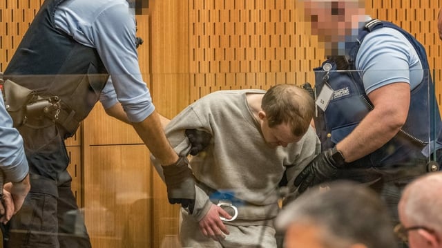 Mann wird von Polizisten in Handschellen abgeführt. Mann wird von Polizisten in Handschellen abgeführt.