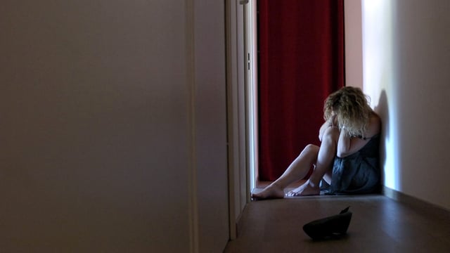 Frau in einem Gang am Boden - sie scheint traurig/depressiv zu sein Frau in einem Gang am Boden - sie scheint traurig/depressiv zu sein