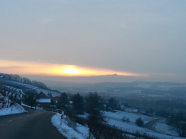 Vom Seerücken blickt man in das leicht mit Schnee gezuckerte Thurtal. Am Horzont ist schwach der Säntis auszumachen. Links vom Säntis erhellt die Sonne etwas die Wolkendecke über dem Mittelland.