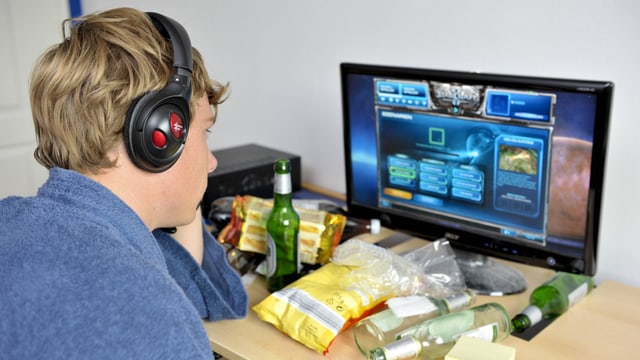 Jugendlicher mit Headset spielt am Computer. Jugendlicher mit Headset spielt am Computer.