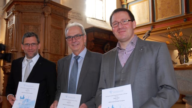 Ils represchentants da la citad da Glion Jan-Andrea Bernhard (mainaproject) ed Aurelio Casanova (pres. comm.) cun Mario Fischer da la CBEE. (da san.) Ils represchentants da la citad da Glion Jan-Andrea Bernhard (mainaproject) ed Aurelio Casanova (pres. comm.) cun Mario Fischer da la CBEE. (da san.)