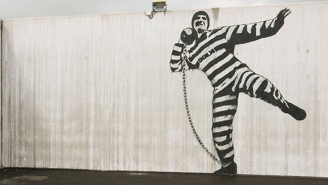 Eine Wand mit einem Graffiti eines Zellinsassen. Eine Wand mit einem Graffiti eines Zellinsassen.