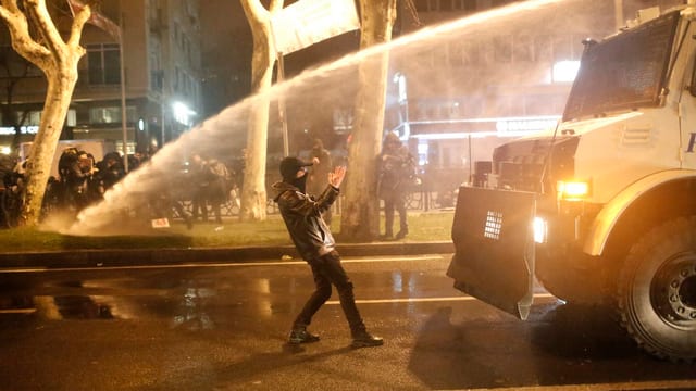 Einzelner Demonstrant vor Wasserwerfer. Einzelner Demonstrant vor Wasserwerfer.