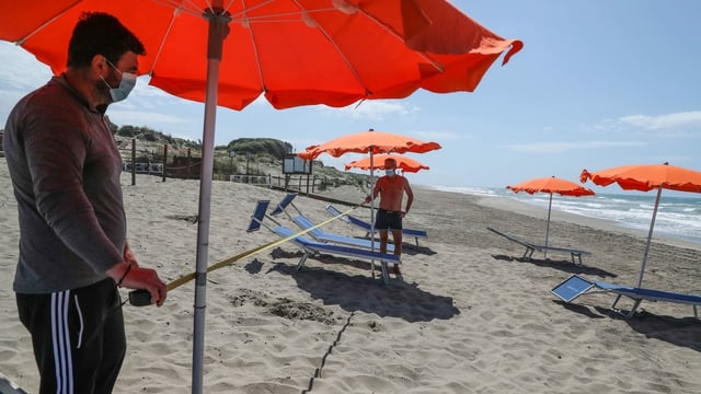 Zwei Männer messen den Abstand am Strand. Zwei Männer messen den Abstand am Strand.