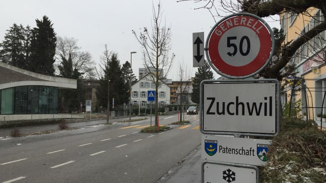 Ortstafel Zuchwil, daneben eine Strasse Ortstafel Zuchwil, daneben eine Strasse