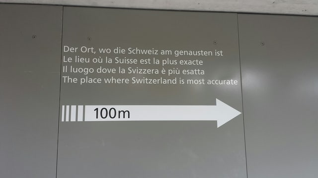 graue Wand mit Aufschrift: Der Ort, wo die Schweiz am Genauesten ist. graue Wand mit Aufschrift: Der Ort, wo die Schweiz am Genauesten ist.