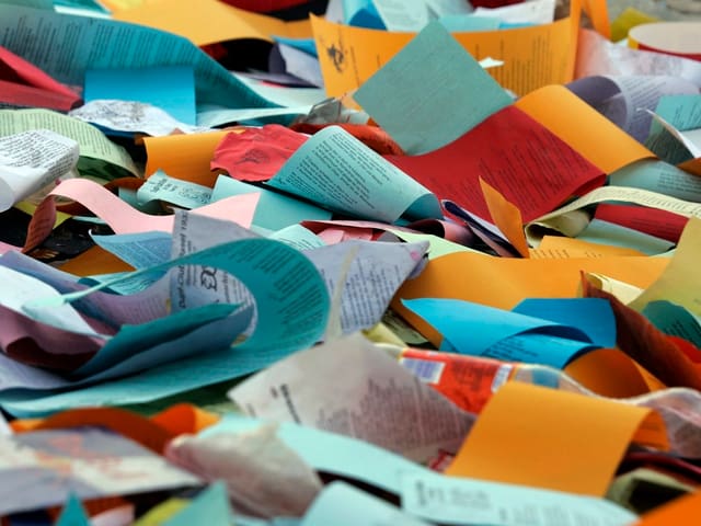 Bunte Zettel liegen wild durcheinander auf dem Boden. Bunte Zettel liegen wild durcheinander auf dem Boden.