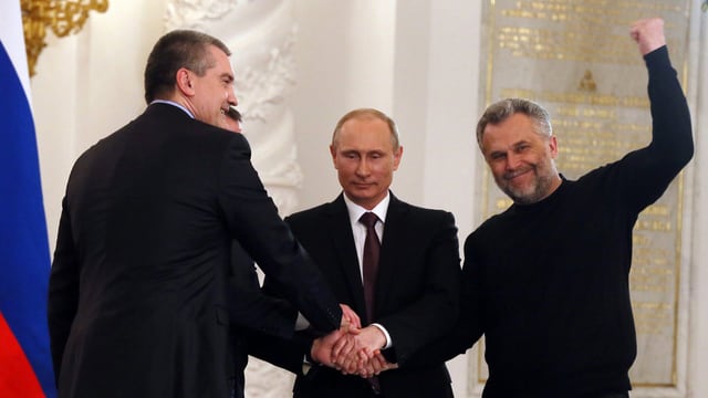 Präsident Putin (mitte), und die Krim-Führung Wladimir Konstantinow und Sergei Aksyonow sowie der Bürgermeister der Hafenstadt Sewastopol schütteln sich die Hände nach der Unterschrift. (keystone) Präsident Putin (mitte), und die Krim-Führung Wladimir Konstantinow und Sergei Aksyonow sowie der Bürgermeister der Hafenstadt Sewastopol schütteln sich die Hände nach der Unterschrift. (keystone)
