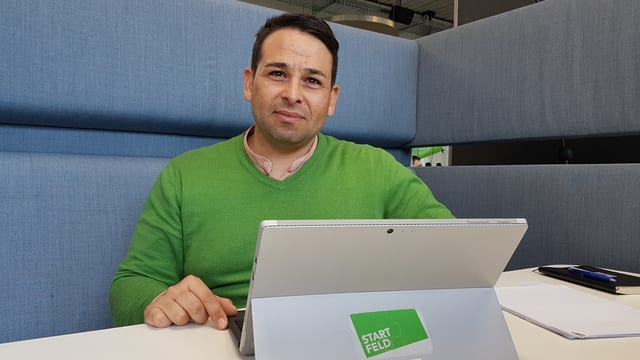 Mann in grünem Pulli vor Tablet Mann in grünem Pulli vor Tablet