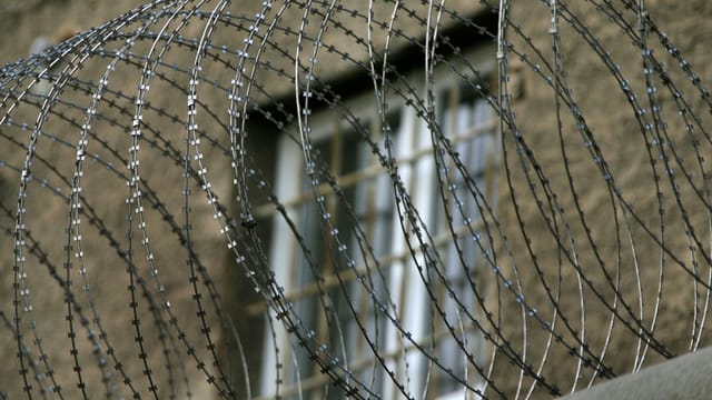 Stacheldraht um ein Gefängnis herum. Stacheldraht um ein Gefängnis herum.
