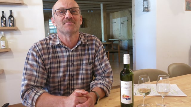 Christian Jäggi sitzt vor einem Glas Weisswein, die Flasche steht neben dme Glas auf dem Tisch. Christian Jäggi sitzt vor einem Glas Weisswein, die Flasche steht neben dme Glas auf dem Tisch.
