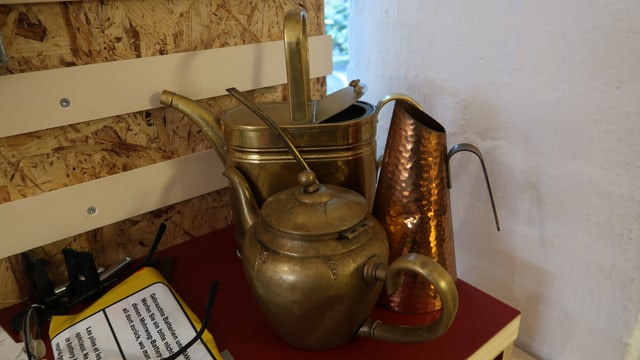 Messingkannen auf einem Regal Messingkannen auf einem Regal