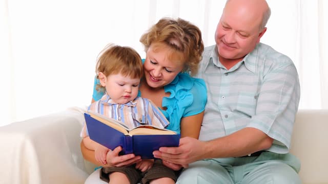 Grosseltern lesen Enkel aus einem Buch vor Grosseltern lesen Enkel aus einem Buch vor