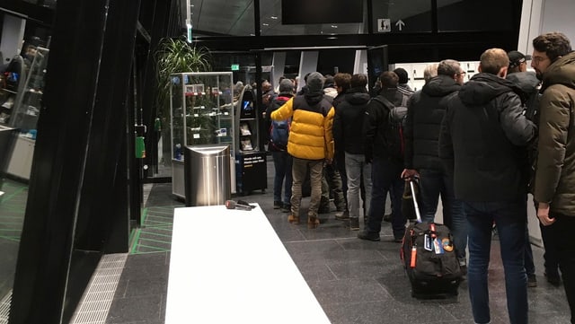 Mehrere Menschen stehen in der Schlange, um auf die Zuschauerterrasse des Flughafens Zürich zu gelangen Mehrere Menschen stehen in der Schlange, um auf die Zuschauerterrasse des Flughafens Zürich zu gelangen